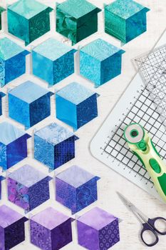 Diamonds stitched in the form of a cube are prepared for sewing into a quilt and quilting accessories.