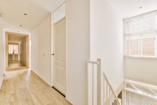 a hallway with white walls and a door and stairs
