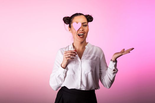 Woman covering one eye with a pink heart