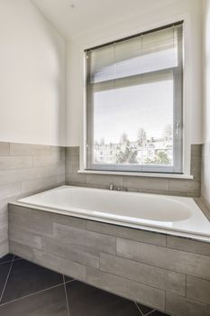 a large bath tub in a bathroom with a window