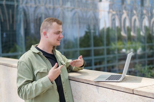 Caucasian man communicates in sign language via video link on laptop. 