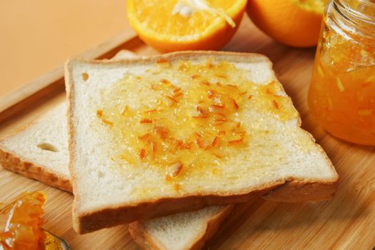 orange fruit spread on a bread on table 