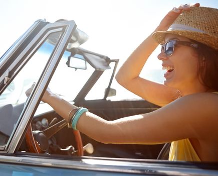 Happy woman, travel and smile for road trip, freedom or summer vacation in the sunny outdoors. Female smiling and driving in happiness for traveling, driving or getaway with sunglasses and hat