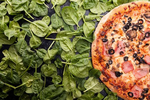 Delicious pizza next to spinach