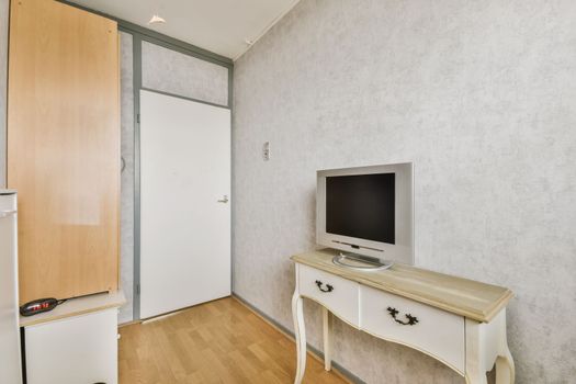 a room with a tv and a white dresser