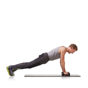 Just a few more reps...A fit young man doing push-ups with a pair of dumbbells while isolated on a white background.