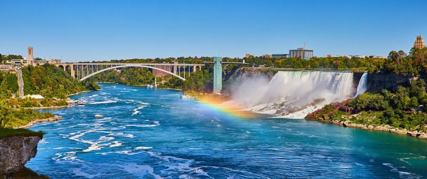 Stunning rainbow over Niagara River looking at American Falls and Rainbow Bridge