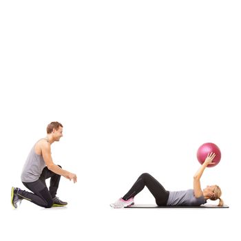 Exercising their abs. A man and woman exercising their abs by passing a medicine ball to each other.