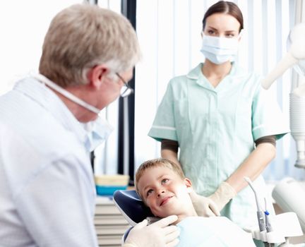 Dentist at work. Portrait of dentist speaking with his young patient in office