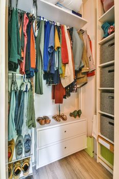 a walk in closet with a dresser and shoes