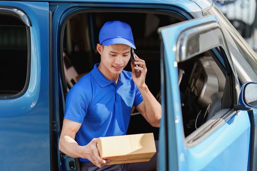 Asian courier with parcel and delivery logistic concept. Delivery man talking with customer by phone