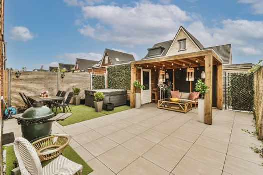 a patio with furniture and a house with a roof