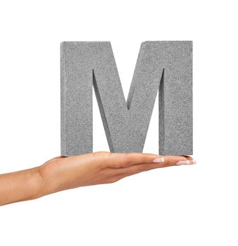 The letter M. A young woman holding a capital letter M isolated on a white background.