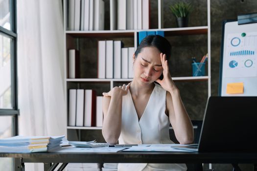 Business woman overwork on laptop computer and neck pain with at work in office, girl stress and illness chronic with office syndrome, health and emotion concept