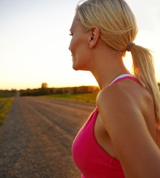 The long road to fitness. A beautiful young sportswoman looking at the sunset.