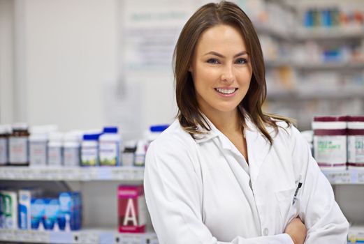 Every customer gets greeted with a caring smile. Portrait of an attractive young pharmacist at work.