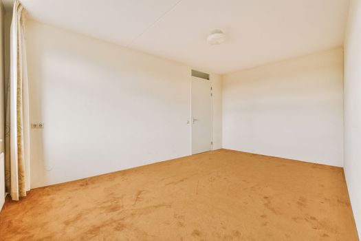 an empty room with white walls and a brown carpet