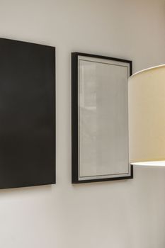 two pictures hanging on a wall with a lamp
