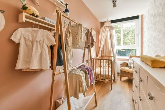 a nursery with a bunk bed and a clothes rack