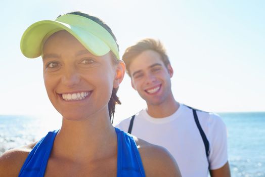 We love exercise. Portrait of a young athletic couple standing outside.
