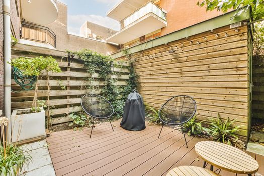 a backyard with a wooden fence and tables and chairs