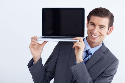 This is worth your money. A young businessman holding up a laptop and smiling.