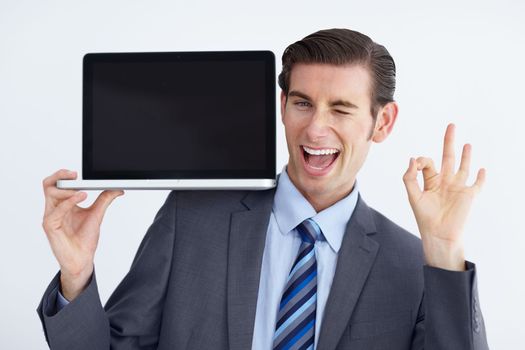 Youd be doing yourself a favor by getting this. A young businessman endorsing a laptop with an a okay hand sign.
