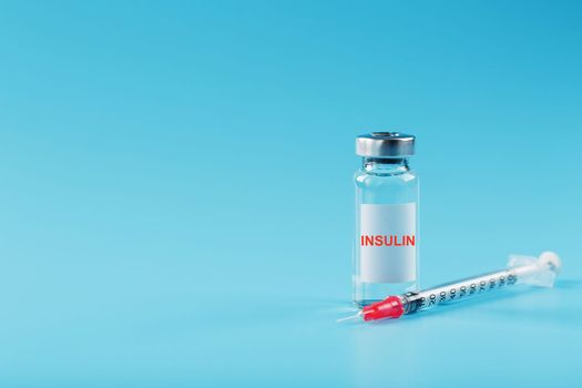 A bottle of insulin hormone and a syringe on the table