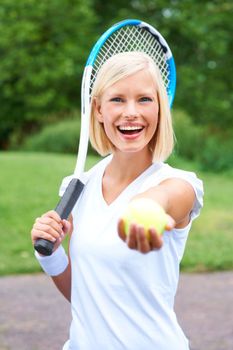 Care to join me for tennis. Portrait of a young female tennis player holding her racquet and offering you the ball.