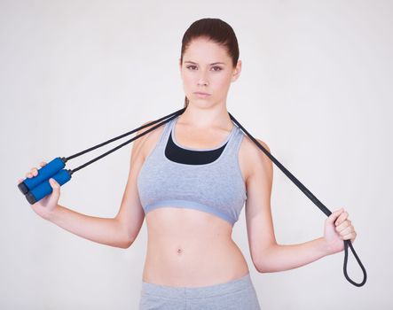 Serious about skipping. Portrait of a serious-looking young woman holding a skipping rope over her shoulders.