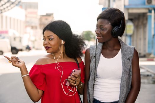 group of two girls with headphones outside