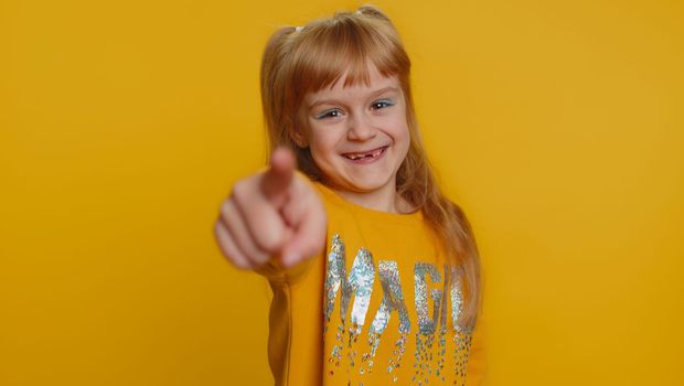 Amused child girl kid pointing finger to camera, laughing out loud funny ridiculous joke reaction