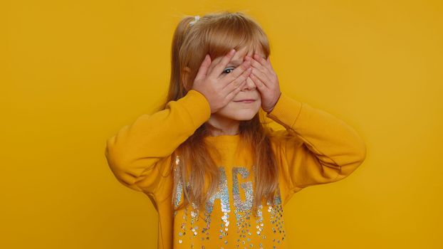 Young preteen child girl closing eyes with hand showing stop gesture, confused shy scared to watch