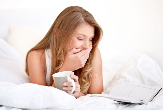 I cant believe i forgot. A young woman looking at her daily planner while enjoying coffee in bed.