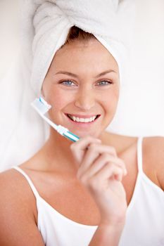 Dental hygiene is important to her. A lovely young woman holding a toothbrush after a refreshing shower.