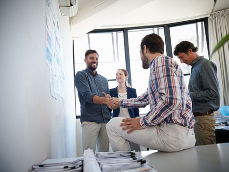Its a win win situation. colleagues shaking hands during a meeting at work.