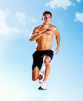 Masculine young man jumping in the air - Outdoor. Portrait of a masculine young man jumping in the air against the sky - Copyspace.