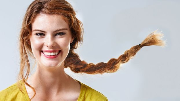 Pure joy. Cropped studio portrait of a happy and beautiful young woman with braided hair.