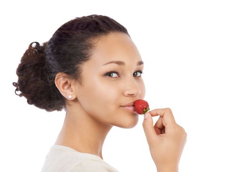 Mmm, this ones ripe...Young woman pressing a fresh strawberry to her lips - isolated on white.