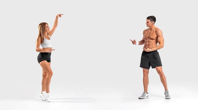 Banner. Fit couple at the gym shows on copy space isolated on white background . Fitness concept. Healthy life style.
