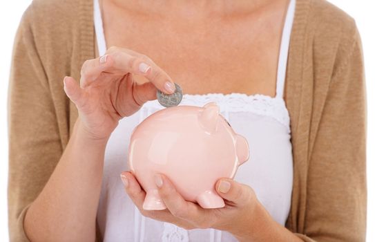Financial stability gives peace of mind. A young woman putting a coin into her piggybank.