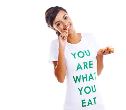 Guess what. Portrait of a young woman holding carrots while wearing a t-shirt saying you are what you eat.