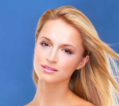 Is this the face of perfection We think so...Isolated portrait of a gorgeous blonde woman with a naturally radiant complexion gazing at you.