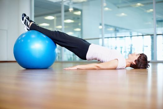Exercise ball workout. Full length of woman using exercise ball during a workout session.