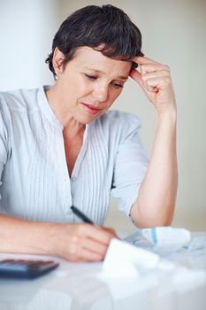 Financial trouble. Tensed female professional calculating taxes in office.
