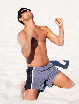Yes Thats another win for me. A young man celebrating a victory on the beach.