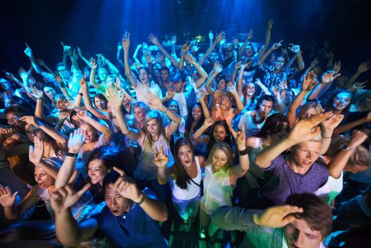 Dance, music and party with audience at concert for rock, festival or disco with live band performance. Celebration, social and nightclub show with crowd of fans listening for rave or new year event