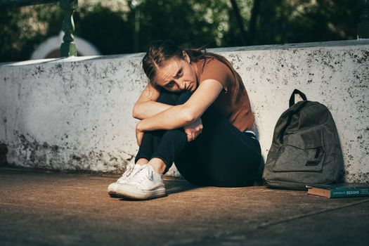 Woman, student and depression in lonely stress, anxiety or mental health problems in the outdoors. Sad and depressed female teenager in distress, loneliness or trouble at school or university