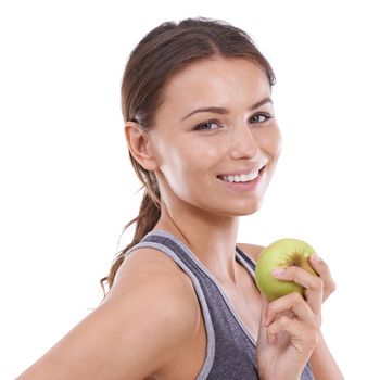 Making healthy choices. A young woman in gymwear holding an apple and smiling at the camera.