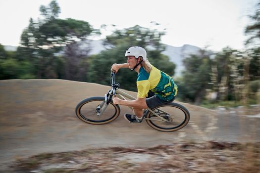 Mountain bike, sports and man with energy, power and action in nature. Training, cycling and fast person in extreme sport on a bike for competition, race or professional event in a park or mountain